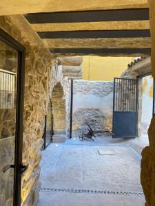Cette chambre en pierre est dotée d'une porte et d'un mur en pierre. dans l'établissement Cal Vallverdú 2I, à Preixana