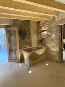 Cette chambre est dotée d'un mur et d'une baignoire en pierre. dans l'établissement Cal Vallverdú 2I, à Preixana