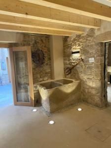 a room with a stone wall and a stone tub at Cal Vallverdú 2I in Preixana