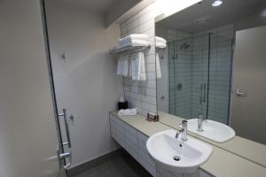a bathroom with two sinks and a mirror at Hotel Ashburton in Ashburton