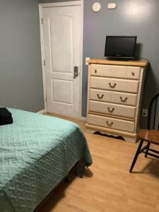 a bedroom with a bed and a dresser with a television at Cozy Apt near BU, Lourdes, UHS in Johnson City