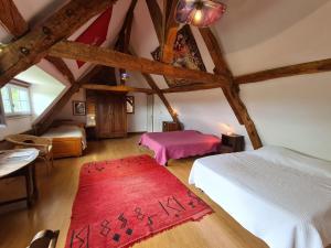 a attic bedroom with two beds and a red rug at Grande chambre calme avec vue, wifi et parking - Le Pêchereau - FR-1-591-559 in Le Pêchereau