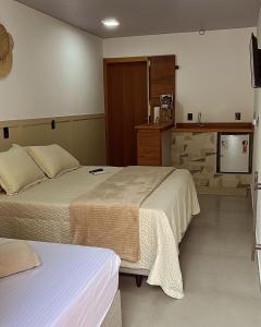 pokój hotelowy z 2 łóżkami i telewizorem w obiekcie Pousada Águas da Grota w mieście Penha