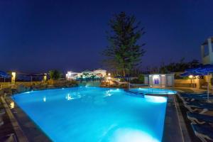 a large swimming pool at night with chairs at Futura Hotel in Maleme