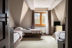 um quarto com 2 camas e uma janela em Dom Wczasowy Grań em Zakopane
