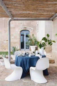 Villa CastelliにあるMasseria Angiulli Piccolo Contrada Angiulli 74023 Grottaglieの白い椅子と青いテーブルクロス