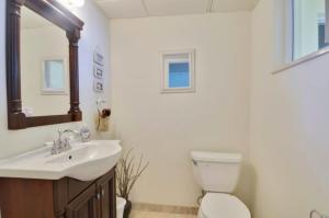 a bathroom with a sink and a toilet and a mirror at Sunshine Place in Islamorada