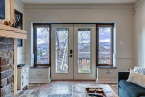 una sala de estar con una puerta con ventanas en 124 Algonquin - Ski In Out Tremblant Mountainside Chalet, en Mont-Tremblant 35 fotos más