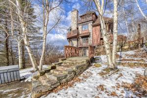 una casa grande con nieve en el suelo en 124 Algonquin - Ski In Out Tremblant Mountainside Chalet, en Mont-Tremblant