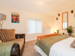 a bedroom with a bed and a couch at 8 Church Lane in Checkley