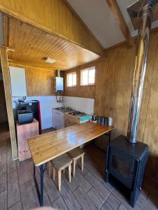 a kitchen with a wooden table and a stove at Siempre Verde in Puerto Tranquilo