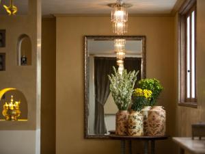 a mirror and two vases with flowers on a shelf at Amnaya Resort Kuta in Kuta