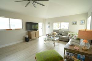 Una sala de estar con un sofá y un televisor. en Twice the Charm, en Cayo Largo