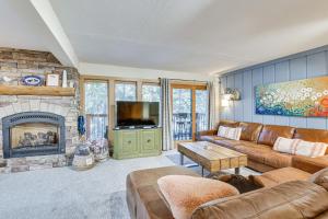 SnowDogs Breck Condo with Fireplace Walk to Lifts في بريكنريدج: غرفة معيشة مع أريكة ومدفأة