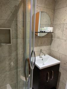 a bathroom with a sink and a shower at Relax Inn Guest House in Brighton & Hove