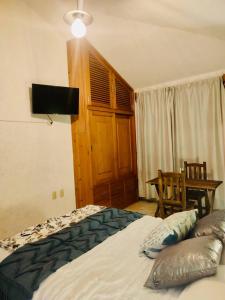 Schlafzimmer mit einem Bett, einem Tisch und einem Fenster in der Unterkunft casa79sancris in San Cristóbal de las Casas