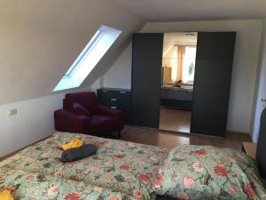 a bedroom with a bed and a chair and a mirror at Sonnige Wohnung mit Balkon in Eppingen