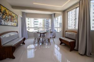 a dining room with a table and chairs and windows at CB62 - Duplex, 4 Dorm Climatizados, Churrasqueira in Balneário Camboriú