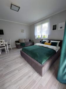 a bedroom with a large bed and a living room at Villa6 in Pobierowo