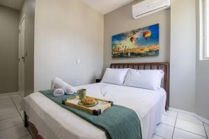 a bedroom with a bed with a tray of food on it at CB62 - Duplex, 4 Dorm Climatizados, Churrasqueira in Balneário Camboriú +57 photos