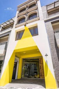 Art Zone في مدينة هوالين: مبنى اصفر وابيض مع مظلات صفراء