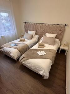 twee bedden naast elkaar in een slaapkamer bij Le Gîte de la Maison Blanche in FlÃ©chin