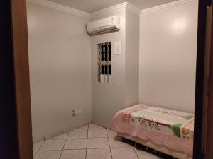 Habitación pequeña con cama y ventilador. en Brasilia Vale Park Way en Brasilia