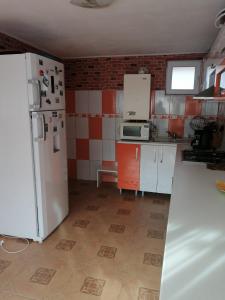 a kitchen with white appliances and red and white tiles at Casuta Bunicilor in Pucioasa