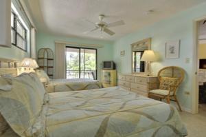 a bedroom with two beds and a ceiling fan at Villa Riolo in Islamorada