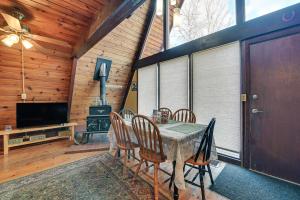 a dining room with a table and chairs and a television at Charming Hunter A-Frame Walk to Ski Lift! in Lanesville