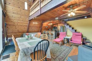 a dining room with a table and chairs and a staircase at Charming Hunter A-Frame Walk to Ski Lift! in Lanesville