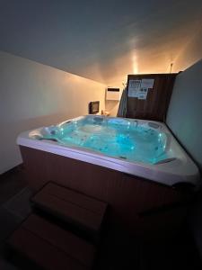 uma banheira de hidromassagem no canto de um quarto em Le Gîte de la Maison Blanche em FlÃ©chin