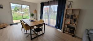 a living room with a dining room table and a living room at Célest' Inn in Cléder