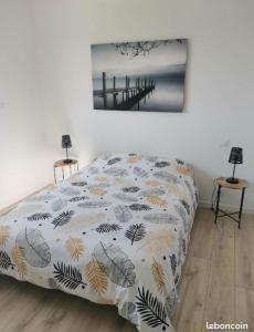 een slaapkamer met een bed en een schilderij aan de muur bij Célest' Inn in Cléder