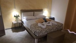 een slaapkamer met een bed met twee schoenen erop bij Nastanza D'arte in Mazara del Vallo
