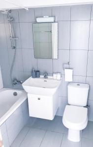 een badkamer met een wastafel, een toilet en een spiegel bij Seaview Apartment (Excellent Location) in Larnaka