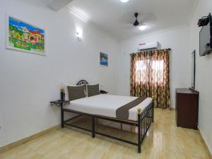 a bedroom with a bed in the corner of a room at Collection O Maizons Lakeview Resort in Arpora