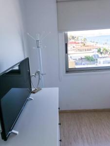 een tv op een tafel in een kamer met een raam bij Seaview Apartment (Excellent Location) in Larnaka