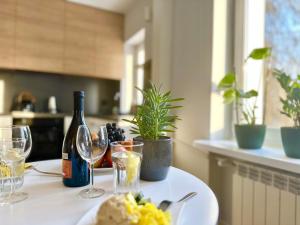 a table with a plate of food and wine glasses at Eastside Warsaw Apartment in Warsaw