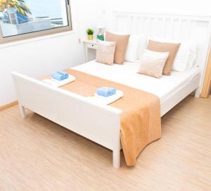 een slaapkamer met een groot wit bed en 2 handdoeken bij Seaview Apartment (Excellent Location) in Larnaka