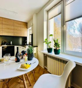 華沙的住宿－Eastside Warsaw Apartment，厨房配有白色的桌子、椅子和植物