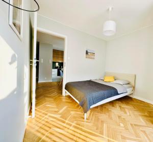 華沙的住宿－Eastside Warsaw Apartment，一间卧室配有一张床,铺有木地板
