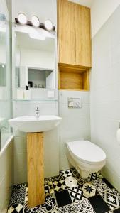 a bathroom with a sink and a toilet at Eastside Warsaw Apartment in Warsaw