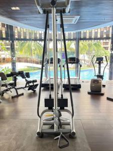 a gym with several exercise bikes and a swimming pool at Orkide Condo By 365Home in Phnom Penh