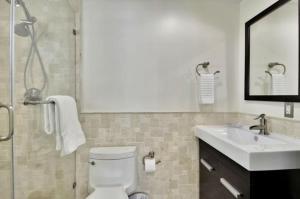 uma casa de banho com um WC, um lavatório e um espelho. em West Plaza Del Lago em Islamorada