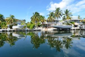 two boats are docked in a marina with palm trees at West Plaza Del Lago in Islamorada