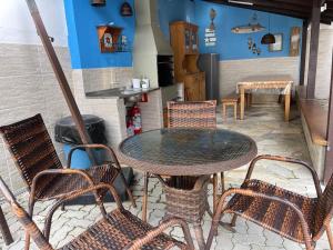 a patio with a table and chairs and a stove at Chalés Camburi in São Sebastião