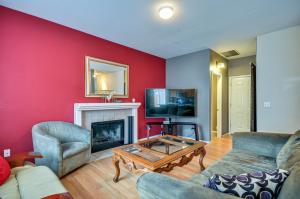 a living room with a red wall and a fireplace at Charming Beaverton Retreat about 12 Mi to Downtown! in Beaverton