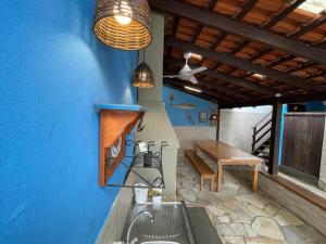 a kitchen with a sink and a blue wall at Chalés Camburi in São Sebastião