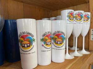 a row of white wine glasses sitting on a table at Chalés Camburi in São Sebastião
